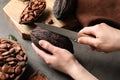 Woman cutting ripe cocoa pod over grey table with products, Royalty Free Stock Photo