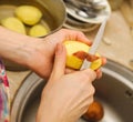 Woman cutting to peel potatoes. Prepare food