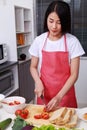 Woman cutting tomato on board in kitchen room Royalty Free Stock Photo