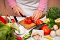 Woman cutting tomato on slices on chopping board Royalty Free Stock Photo