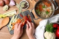 Woman cutting vegetables for bouillon at wooden table, top view Royalty Free Stock Photo