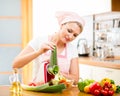 Woman cutting vegetables with device at the kitchen table Royalty Free Stock Photo