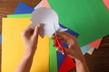 Woman cutting white paper with scissors at wooden table, top view Royalty Free Stock Photo