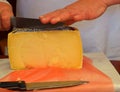 Woman cutting yelow cheese.