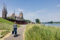 Woman cycling along river Meuse near Dutch village Cuijk Royalty Free Stock Photo