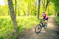 Woman cycling a mountain bike in city park, summer day Royalty Free Stock Photo