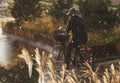 Woman cycling in rain with rainwear - rain drops falling heavy