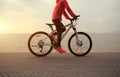 Woman cyclist cycling at sunrise seaside