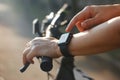 Woman cyclist hands with heart rate icon on smart watch, bicycle at summer trail Royalty Free Stock Photo