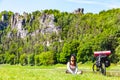 Woman cyclist with loaded bicycle having break while travelling