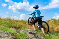 Woman cyclist pushing her bike up a steep slope