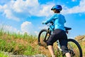 Woman cyclist pushing her bike up a steep slope