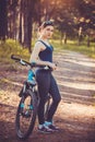 Woman cyclist rides in the forest on a mountain bike. Royalty Free Stock Photo