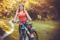 Woman cyclist rides in the forest on a mountain bike. Royalty Free Stock Photo