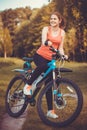 Woman cyclist rides in the forest on a mountain bike. Royalty Free Stock Photo