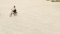 Woman cyclist riding a bike on paved road at square on summer day Royalty Free Stock Photo