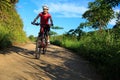 Woman cyclist riding mountain bike on forest trail Royalty Free Stock Photo