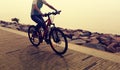 Woman Cyclist Riding Mountain Bike on seaside road Royalty Free Stock Photo