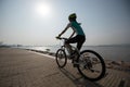 woman cyclist riding mountain bike on seaside Royalty Free Stock Photo