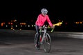 Woman Cyclist Riding Road Bike at Night in the City. Healthy Lifestyle and Urban Sport Concept Royalty Free Stock Photo