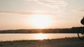 Woman cyclist at sunset. Professional cyclist starting to ride bicycle in evening sunshines. Cycling motivation. Triathlon concept