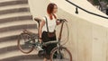 Woman cyclist walking down stairs and holding bicycle in arms. Woman bike city Royalty Free Stock Photo