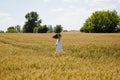 Woman dance wheat field. smiling and have fan. feel happiness. Young beautiful woman in romantic dress whirls in field. beautiful