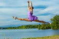 Woman dancer performing air split over a Connecticut reservoir Royalty Free Stock Photo