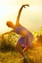 Woman dancing with intense reflections of the setting sun