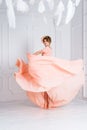 Woman dancing in pink evening dress flying on wind. Waving fabric, fashion shot. Royalty Free Stock Photo