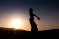 Woman dancing to the famous Arab belly dance. With sunset in the arid desert plain of Namibe. Africa. Angola Royalty Free Stock Photo