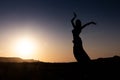 Woman dancing to the famous Arab belly dance. With sunset in the arid desert plain of Namibe. Africa. Angola Royalty Free Stock Photo