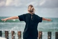 Woman dancing to music on sea coast, rear view, dancers at outdoor art performance music festival