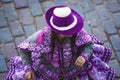 Woman dancing with typical Cuzco clothes with hats at the Inti Raymi Sun Festival, overhead view with Peru cobblestones background