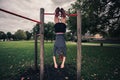 Woman dangling from pullup bars Royalty Free Stock Photo