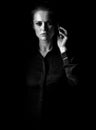 Woman in dark dress isolated on black talking on mobile phone Royalty Free Stock Photo