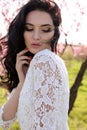 Woman with dark hair in elegant dress posing in blossom garden Royalty Free Stock Photo