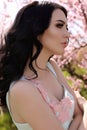 Woman with dark hair in elegant dress posing in blossom garden Royalty Free Stock Photo