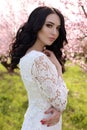 Woman with dark hair in elegant dress posing in blossom garden Royalty Free Stock Photo