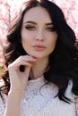 Woman with dark hair in elegant dress posing in blossom garden Royalty Free Stock Photo