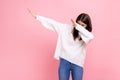 Woman with dark hair showing popular internet meme pose, celebrating success victory, dabbing trends