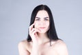 Woman with dark hair smiling and touching her cheek by hand. Beauty concept Royalty Free Stock Photo