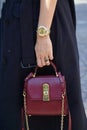 Woman with dark red leather Ferragamo bag and Rolex Daytona watch before Msgm fashion show,