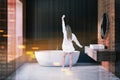 Woman in dark wooden bathroom interior, sink, tub Royalty Free Stock Photo