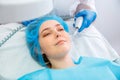 Woman during darsonval cosmetology procedure for skin care health lies at cosmetologist dermatologist visit. Beautician
