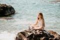 Woman with daughter bilds stones pyramid on seashore on a sunny day on the blue sea background. Happy family holidays Royalty Free Stock Photo