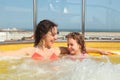 Woman with daughter both smiling in hot tub