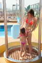 Woman with daughter both wearing swimming suit