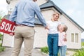 woman with daughter buying new house and shaking hand of male realtor with sold sign Royalty Free Stock Photo