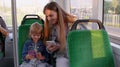 Child girl with mother using mobile phone internet social network application while traveling by bus Royalty Free Stock Photo